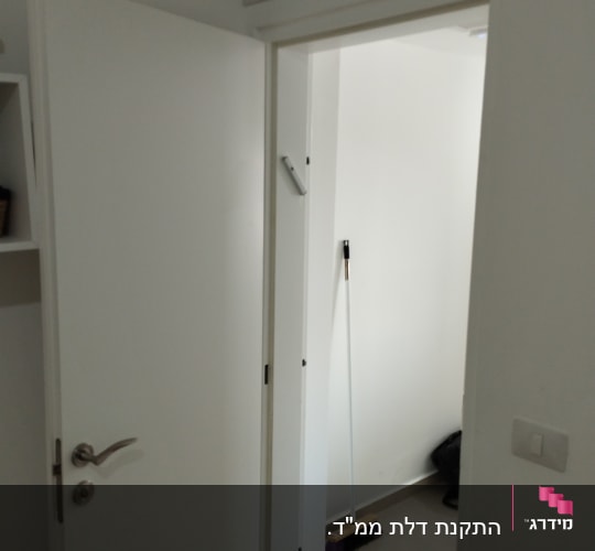 דלת לבנה פתוחה עם ידית מתכת